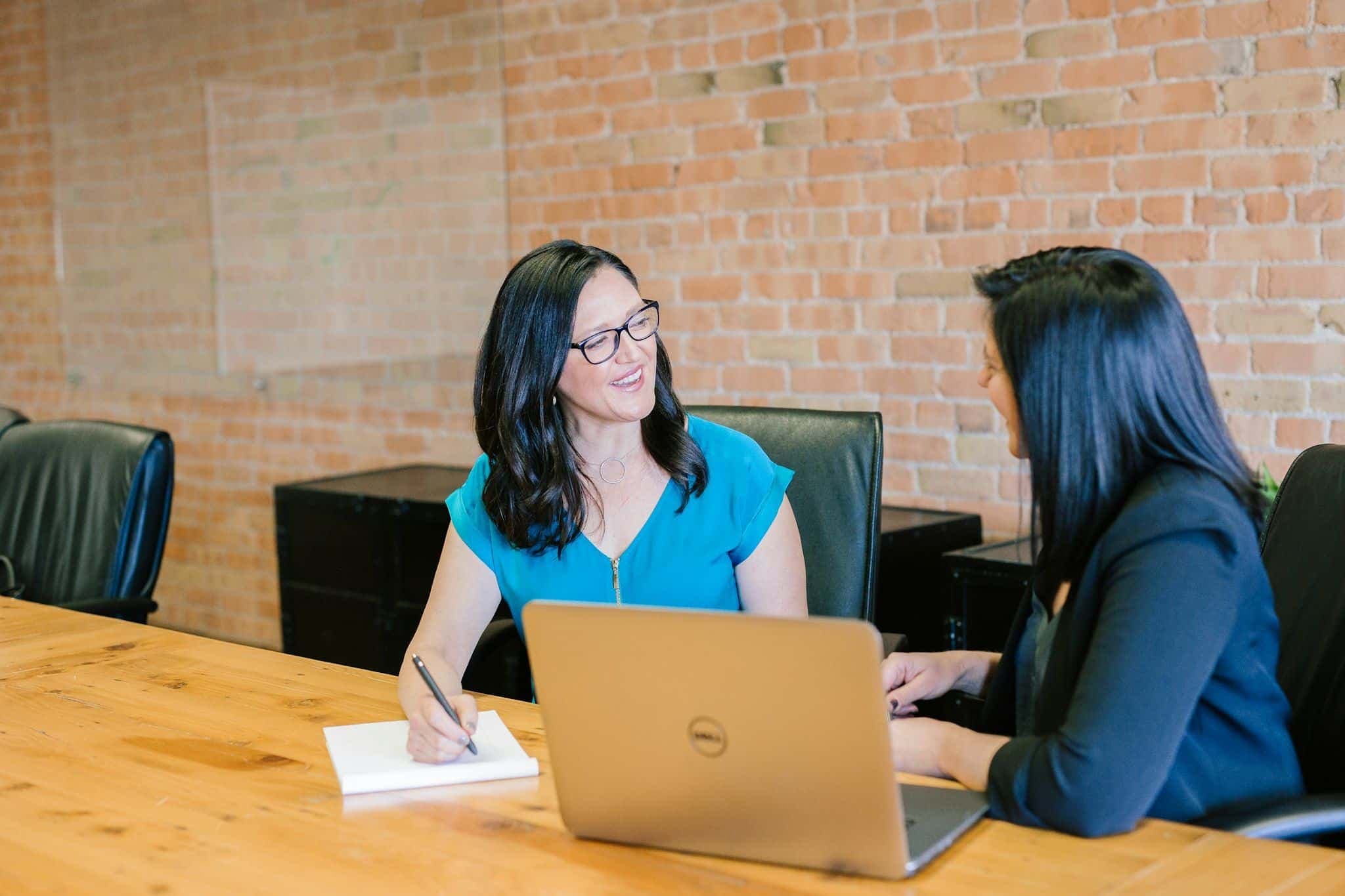 Two people in an interview, facing each other across a table.