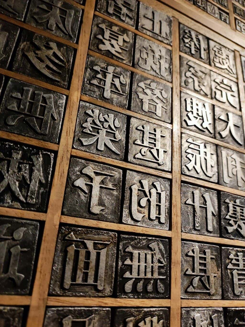 A wooden tray of metal movable-type printing blocks.