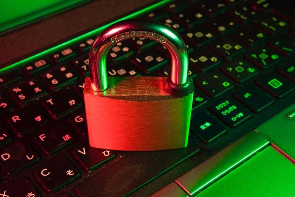 A red padlock resting on a black laptop keyboard.