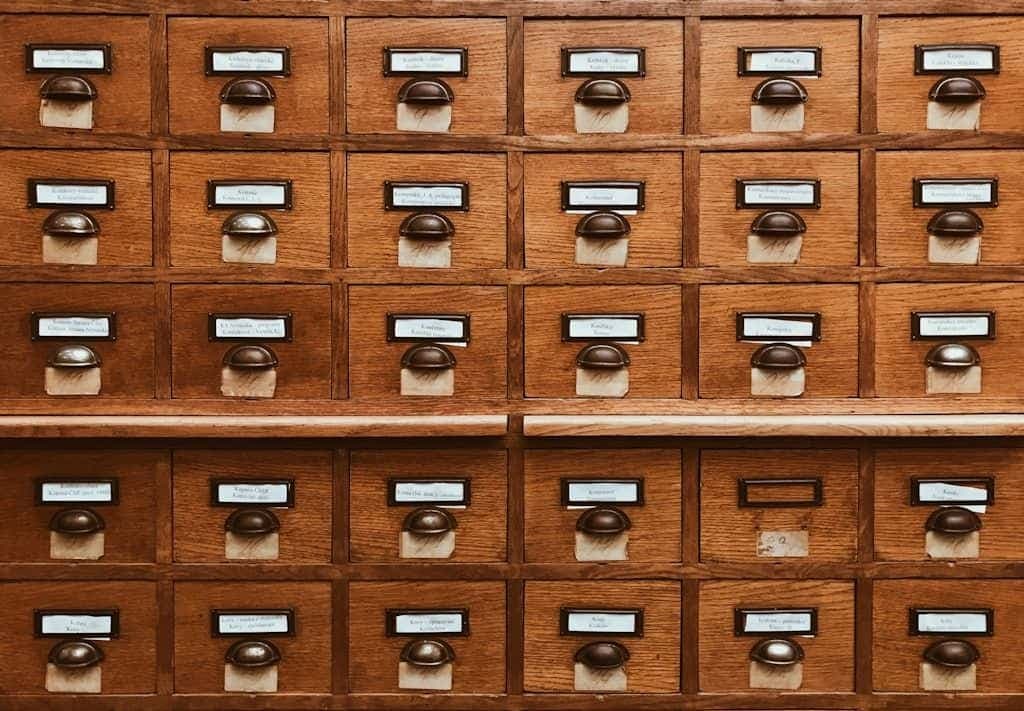 Rows of labelled wooden card-catalog drawers in a library.