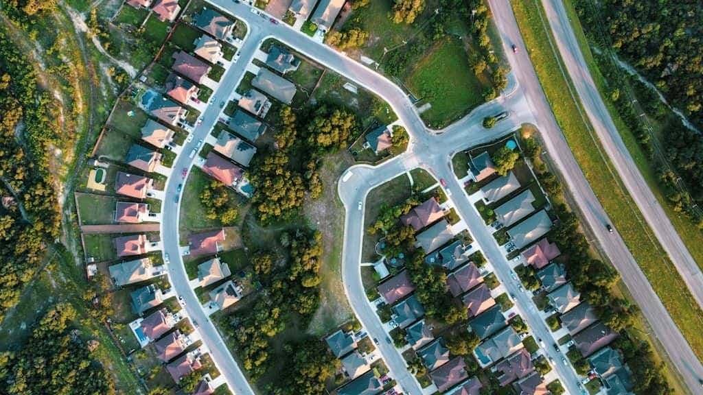 Aerial view of a suburban neighborhood with winding streets and rows of houses.