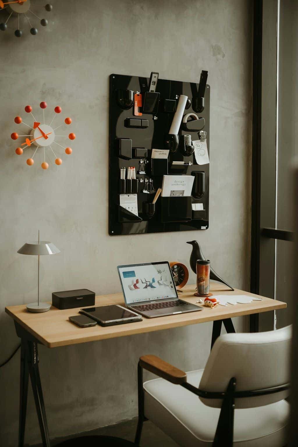 A tidy desk workspace with an open laptop, phone, and notebook.