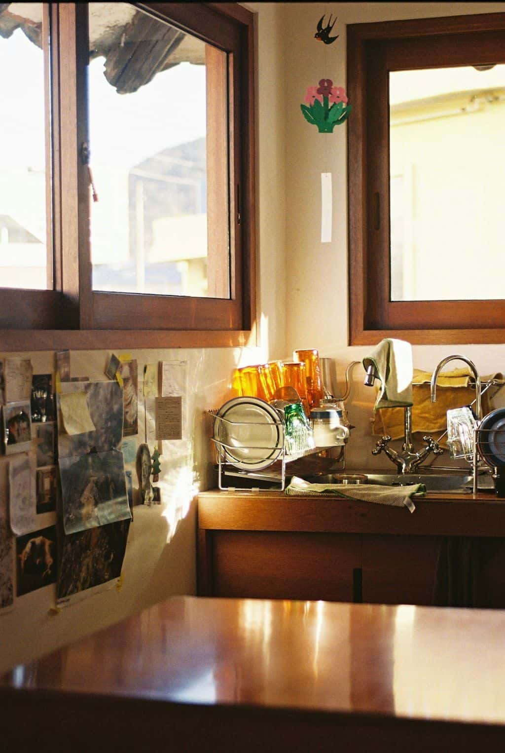 Soft daylight streaming into a kitchen with wooden window frames over a clean counter.