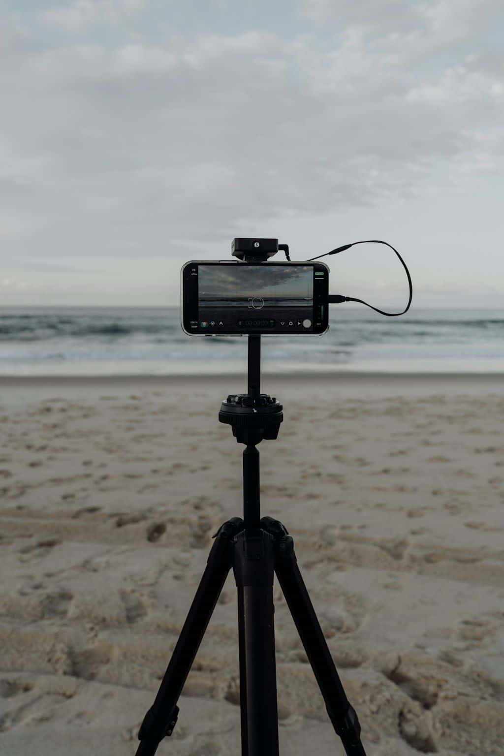 A smartphone mounted on a small tripod, ready to take a steady photo.