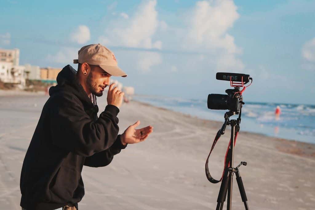 A person holding a camera, shooting footage outdoors.