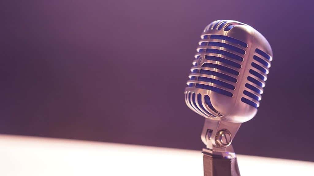 A studio condenser microphone against a black background.