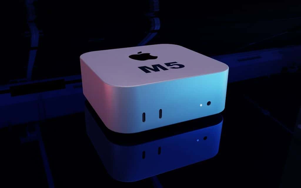 A Mac mini on a desk next to a Magic Keyboard and a small plant.