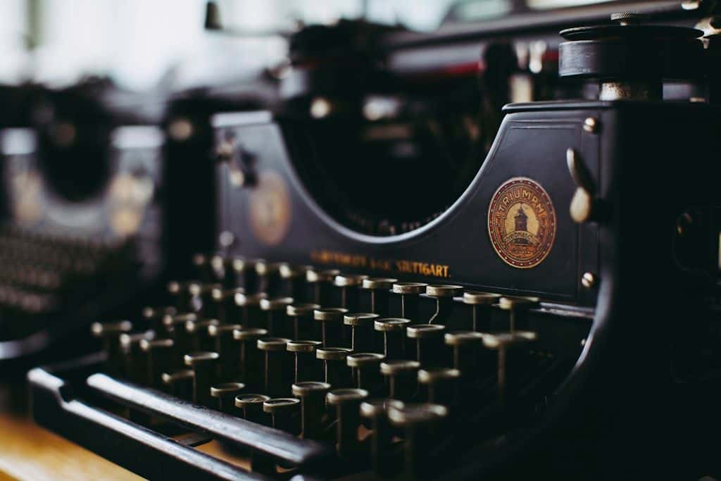 A black and white close-up of a vintage Triumph typewriter, keys catching the light.